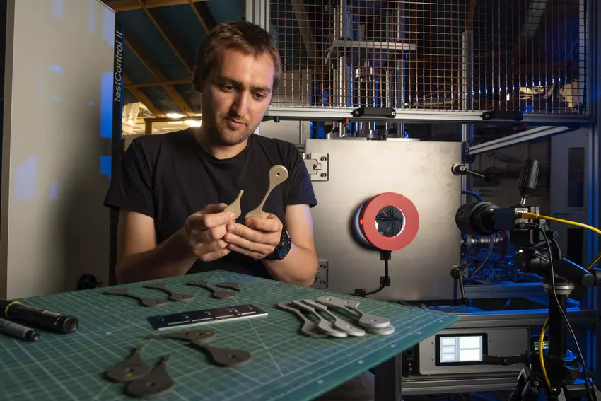 Charlie Patterson untersucht Proben von 3D-gedrucktem Material, das auf dem NextSpace TestRig getestet wurde