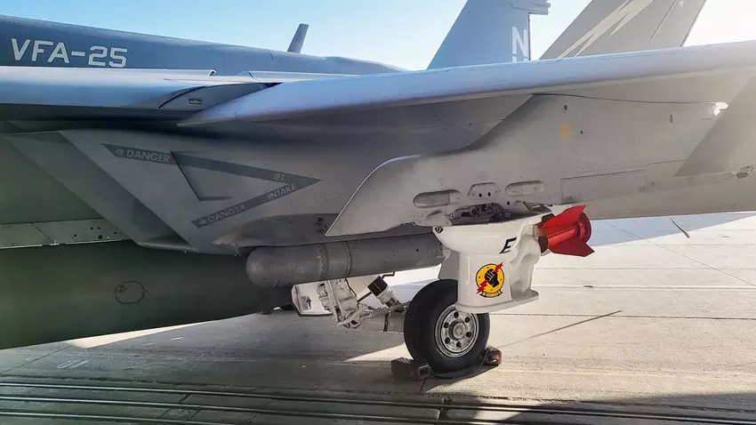 U.S. Navy zeigt F/A-18E Block III Super Hornet Kampfflugzeug mit einer Toilettenschüssel als Bombe
